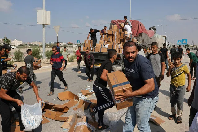People unpack boxes of humanitarian aid from a truck that entered the southern Gaza Strip from Egypt via the Rafah border crossing on November 2, 2023, as battles between Israel and the Palestinian Hamas movement continue. (Photo by Mohammed Abed/AFP Photo)