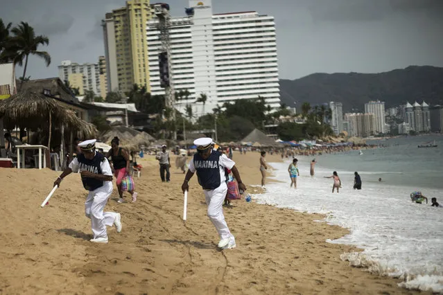 Mexican Marines patrolling the beach run to avoid a wave on April 2, 2015 in Acapulco, Mexico. (Photo by Jonathan Levinson/The Washington Post)