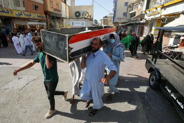 Mourners carry the coffin of a victim, who was killed in a fire that broke out at al-Hussain coronavirus hospital in Nassiriya, during a funeral in Najaf, Iraq, July 13, 2021. (Photo by Alaa Al-Marjani/Reuters)
