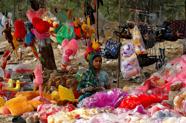 A woman selling toys waits for customers at a roadside shop in Ahmedabad, India, January 20, 2017. (Photo by Amit Dave/Reuters)