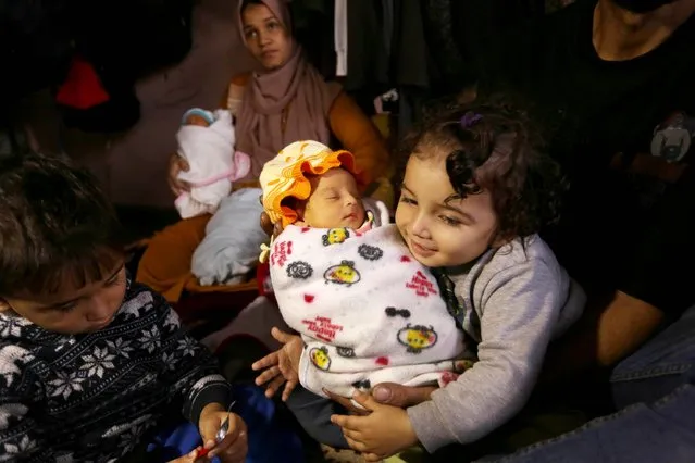 Palestinian Iman Al-Masri (rear), who leaves her home in Beit Hanoun to escape from Israeli bombardment, is seen with her quadruplets, one of them is still being treated in the hospital, and other children as Al-Masri family takes shelter at a school in Deir al-Balah, Gaza on December 26, 2023. (Photo by Ashraf Amra/Anadolu via Getty Images)