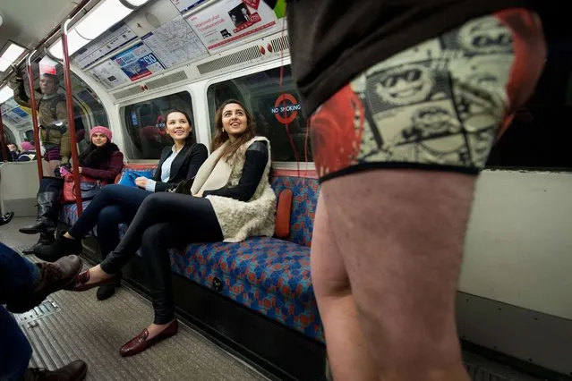 Participants in the13th annual International “No Pants Subway Ride” travel on a London underground train in London, on January 12, 2014. (Photo by Leon Neal/AFP Photo)