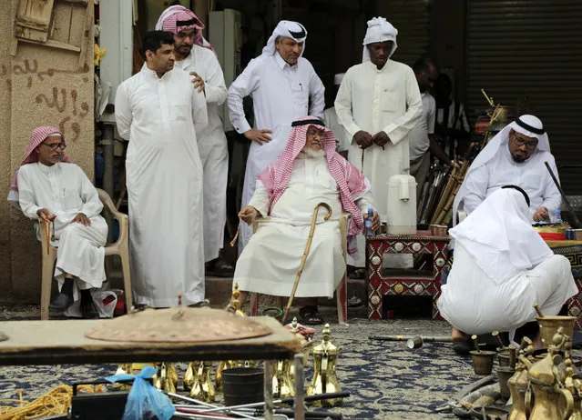In this April 16, 2015 photo, Saudi men haggle at al-Aqeeliya open-air auction market, in Riyadh, Saudi Arabia. The market is far from the upscale malls and designer boutiques found in other parts of the capital, where arguing over the price would be considered un-chic. (Photo by Hasan Jamali/AP Photo)