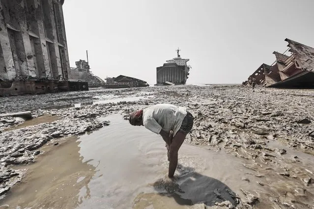 A ship breaking workertakes a breather amongst the water logged sandy beach in Sitakunda Beach, Bangladesh, February 2012. (Photo by Jan Møller Hansen/Barcroft Images)