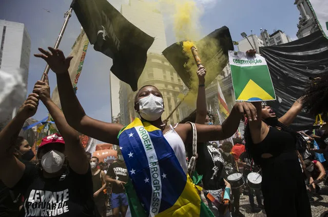 A woman, wrapped in a Brazilian national flag, chats slogans during a protest against Brazilian President Jair Bolsonaro calling for his impeachment over his government‚Äôs handling of the pandemic and accusations of corruption in the purchases of COVID-19 vaccines, in Rio de Janeiro, Brazil, Saturday, October 2, 2021. (Photo by Bruna Prado/AP Photo)
