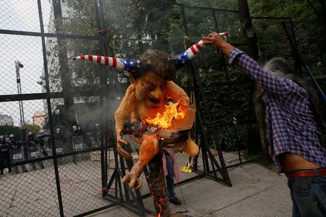 A demonstrator holds a burning effigy of U.S. President Donald Trump during a protest against a fuel price hike outside the U.S. Embassy in Mexico City, Mexico January 31, 2017. (Photo by Henry Romero/Reuters)