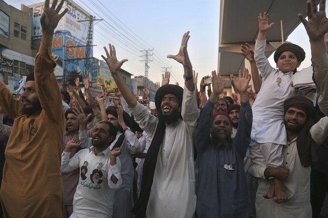 Supporters of Tehreek-e-Labaik Pakistan, a radical Islamist political party, chant religious slogans during a sit-in protest demanding the release of their leader, in Lahore, Pakistan, Thursday, October 21, 2021. Thousands of Islamists are protesting in the eastern city of Lahore, demanding the release of their leader Saad Rizvi, who was arrested in April amid protest against France over depictions of Islam's Prophet Muhammad. (Photo by K.M. Chaudary/AP Photo)