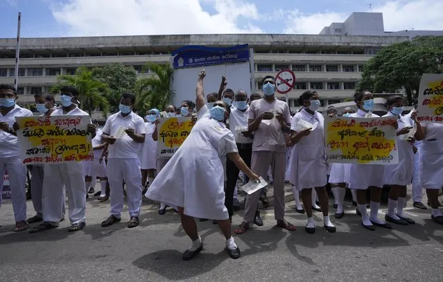 Sri Lankan health workers representing joint trade unions shout slogans demanding due financial benefits and personal protective equipment to secure from coronavirus during half a day strike action in Colombo, Sri Lanka, Friday, October 8, 2021. (Photo by Eranga Jayawardena/AP Photo)
