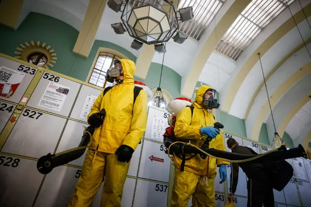 Specialists wearing personal protective equipment (PPE) spray disinfectant while sanitizing the Kazansky railway station amid the outbreak of the coronavirus disease (COVID-19) in Moscow, Russia on November 2, 2021. (Photo by Maxim Shemetov/Reuters)