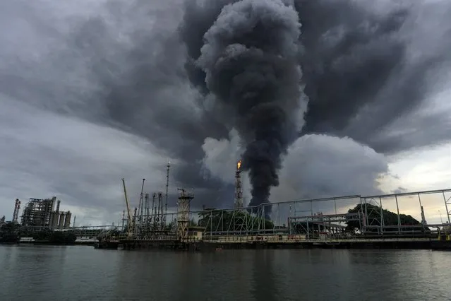 Thick smoke rises from a burning tank at the state oil company Pertamina in Cilacap on November 14, 2021. (Photo by Dida Nuswantara/AFP Photo)