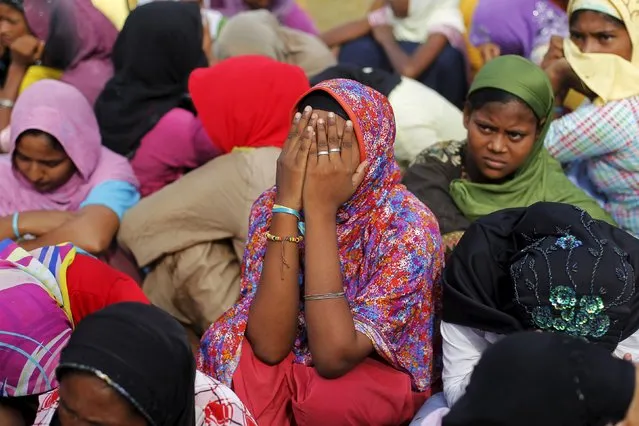 A Rohingya migrant woman, who arrived with others in Indonesia by boat, covers her face as she waits for breakfast inside a temporary compound for refugee in Kuala Cangkoi village in Lhoksukon, Indonesia's Aceh Province May 17, 2015. (Photo by Reuters/Beawiharta)