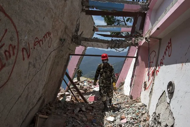 A Nepalese military personnel walks inside a collapsed building after Tuesday's earthquake at Charikot Village, in Dolakha, Nepal, May 14, 2015. (Photo by Athit Perawongmetha/Reuters)