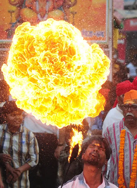 An Indian Hindu devotee demonstrates firebreathing skills during a religious procession to mark the Hindu festival of Maha Shivratri in Allahabad on February 24, 2017. Hindus mark the Maha Shivratri festival by offering prayers and fasting to worship Lord Shiva, the god of destruction. (Photo by Sanjay Kanojia/AFP Photo)