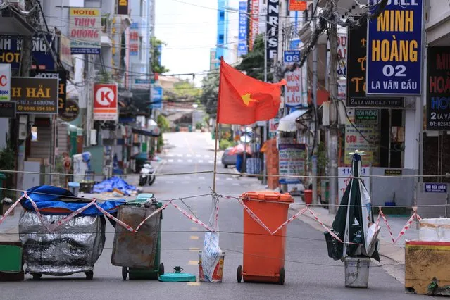 A street is blocked with carts and trash cans during a virus lockdown in Vung Tau, Vietnam on September 13, 2021. More than a half of Vietnam is under a lockdown order to contain its worst virus outbreak yet. (Photo by Hau Dinh/AP Photo)
