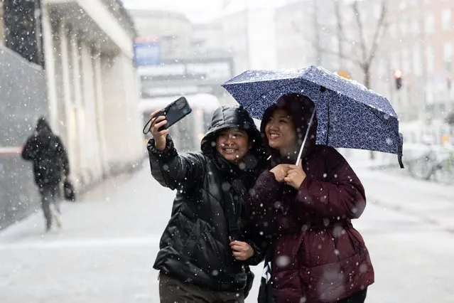 Nurses Charisse (L) and Jiselle take a picture in snowy Dublin after finishing their night shift at the Rotunda Hospital in the last decade of February 2024. (Photo by Sam Boal/Collins Photos)
