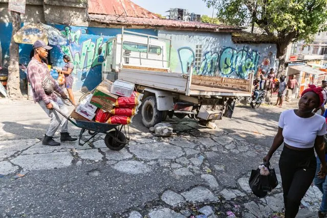 A man pushes a wheelbarrow of food supplies down the street in petion-ville, amid the ongoing insecurity and political instability in Port-au-Prince, Haiti, March 21, 2024. (Photo by Guerinault Louis/Anadolu via Getty Images)