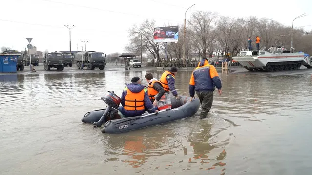 Rescuers ride a boat in a flooded street of Orsk, Russia on April 9, 2024. (Photo by Reuters TV)