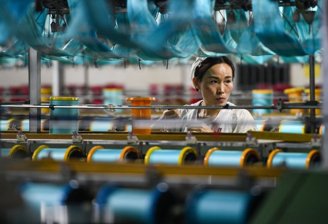 An employee works on the production line of silk products at the workshop of Anhui Jingjiu Silks Co., Ltd. on April 16, 2024 in Fuyang, Anhui Province of China. (Photo by VCG/VCG via Getty Images)