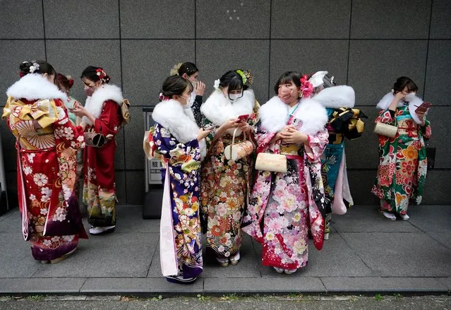 Kimono-clad young Japanese women wearing protective face masks gather near the venue holding the Coming of Age Day ceremony amid the coronavirus disease (COVID-19) pandemic, in Yokohama, south of Tokyo, Japan, 10 January 2022. Coming of Age Day celebrates all those who reached 20 years of age, which is considered adulthood in Japan. (Photo by Franck Robichon/EPA/EFE)