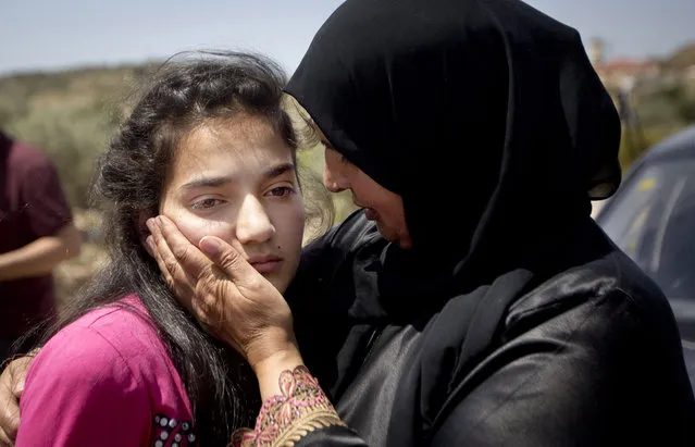 Sabha al-Wawi, right, Palestinian mother of 12-year-old Dima al-Wawi, imprisoned by Israel for allegedly attempting to carry out a stabbing attack, comforts her daughter, after her release from an Israeli prison, at Jabara checkpoint near the West Bank town of Tulkarem, Sunday, April 24, 2016. Al-Wawi who was imprisoned after she confessed to planning a stabbing attack in a West Bank settlement has been released Sunday. (Photo by Majdi Mohammed/AP Photo)