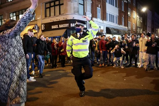 Policeman dances with people partying along a street in Soho, as the coronavirus disease (COVID-19) restrictions ease in London, Britain, April 17, 2021. (Photo by Henry Nicholls/Reuters)