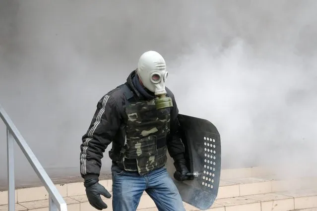A Pro-Russian activist stands during the mass storming of a police station in the eastern Ukrainian town of Horlivka Monday, April 14, 2014.  Several government buildings have fallen to mobs of Moscow loyalists in recent days as unrest spreads across the east of the country. (Photo by Efrem Lukatsky/AP Photo)