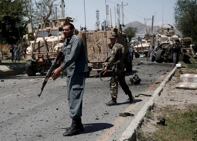 Afghan policemen stand at the site of a suicide bomb attack in Kabul, Afghanistan June 30, 2015. (Photo by Ahmad Masood/Reuters)