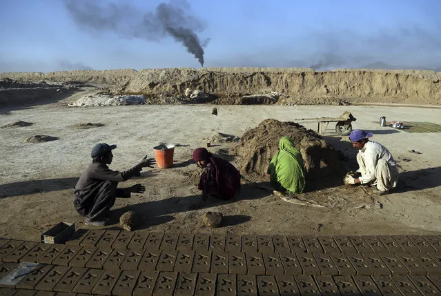 In this Wednesday, June 19, 2019, photo, Atiqullah, 30, right, and his son Kamran, 10, left, work at a brick factory on the outskirts of of Kabul, Afghanistan. “My children wake up early in the morning and right after prayers they come here for work, so they don’t have time for school”, said Atiqullah, who like many Afghans has only one name. “These days if you don’t work, you cannot survive”. (Photo by Rahmat Gul/AP Photo)