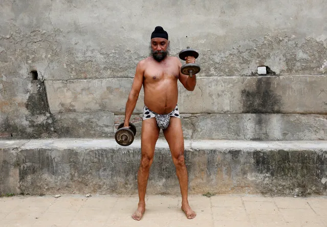 A man uses dumbbells during a practice session at a traditional wrestling training centre called “Akhaara” in Jammu March 31, 2017. (Photo by Mukesh Gupta/Reuters)