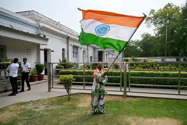 A supporter (R) of Indian National Congress (INC) party waves India's national flag after counting of votes began for India's general election, at the INC headquarter in New Delhi on June 4, 2024. Vote counting began in India's election on June 4, with Prime Minister Narendra Modi all but assured a triumph for his Hindu nationalist drive that has thrown the opposition into disarray and deepened concerns for minority rights. (Photo by Arun Sankar/AFP Photo)