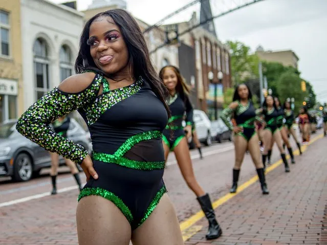 A member of Xplosive dancing dolls smiles as she performs during one of two Juneteenth parades on Saturday, June 19, 2021 along Saginaw Street in downtown Flint, Michigan. The United States marked Juneteenth for the first time as a federal holiday commemorating the end of the legal enslavement of Black Americans. (Photo by Jake May/MLive.com via AP Photo)