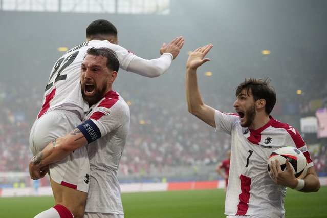 Georgia's Georges Mikautadze, left, celebrates with his teammates after scoring his side's opening goal during a Group F match between Turkey and Georgia at the Euro 2024 soccer tournament in Dortmund, Germany, Tuesday, June 18, 2024. (Photo by Alessandra Tarantino/AP Photo)