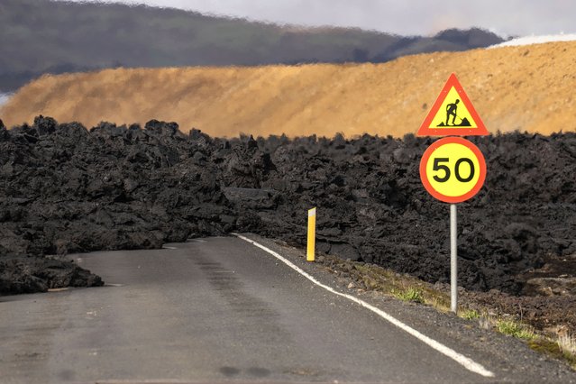 A road is covered by lava flow from a volcano in Grindavik, Iceland, Thursday, May 30, 2024. Lava continued to spurt from a volcano in southwestern Iceland on Thursday but the activity had calmed significantly from when it erupted a day earlier.(Photo by Marco di Marco/AP Photo)