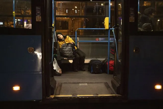 A boy from Ukraine sleeps on a bus after arriving at Keleti station in Budapest, Hungary, on Friday, March 18, 2022. UNHCR, the U.N. refugee agency, has said fighting that has followed Russia’s invasion of Ukraine on Feb. 24 has sparked Europe’s gravest refugee crisis since World War II. (Photo by Anna Szilagyi/AP Photo)