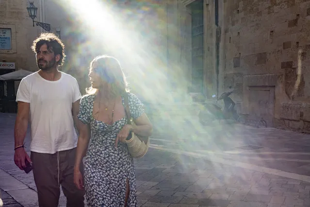 A couple walk down a street during sunset in the old part of Lecce, southern Italy, Monday, September 16, 2019. (Photo by Alexander Zemlianichenko/AP Photo)