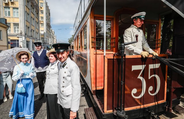 Participants in contemporary costumes pose in front of the horse-drawn tram “Conca” (1872) during the street exhibition “Retro Tram Parade” as part of marking the 125th anniversary of the city tramway service in Moscow, Russia on 13 July 2024. (Photo by Yuri Kochetkov/EPA/EFE)