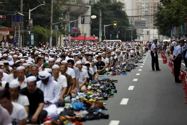 Muslims attend a prayer session on a street near a mosque on Eid al-Fitr, in Shanghai, July 18, 2015. The Eid al-Fitr festival marks the end of the holy Muslim fasting month of Ramadan. (Photo by Aly Song/Reuters)