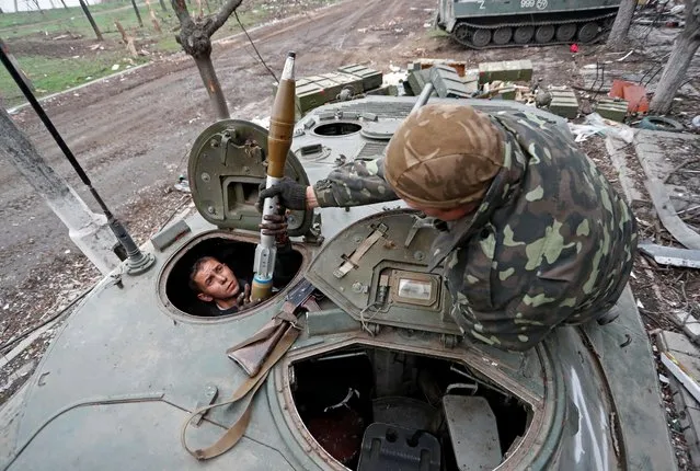 Service members of pro-Russian troops load rocket-propelled grenades into an infantry combat vehicle during fighting in Ukraine-Russia conflict near a plant of Azovstal Iron and Steel Works company in the southern port city of Mariupol, Ukraine on April 12, 2022. (Photo by Alexander Ermochenko/Reuters)
