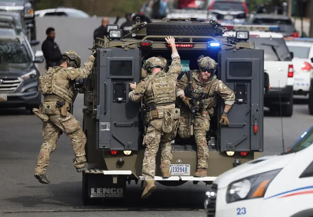 An FBI tactical team deploys from an armored vehicle at the scene of a reported shooting and active shooter near Edmund Burke Middle School in the Cleveland Park neighborhood of Northwest Washington, U.S., April 22, 2022. (Photo by Evelyn Hockstein/Reuters)