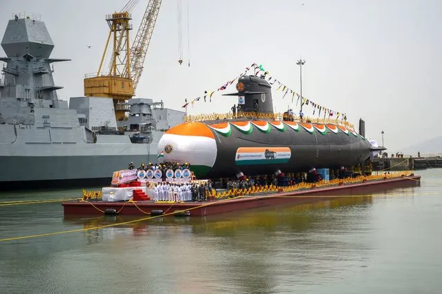 The Indian Navy's Vaghsheer, the sixth and final submarine of Project-75, gets pulled into the water for sea trials during its launch ceremony at the Mazagon Dock Shipyard in Mumbai on April 20, 2022. (Photo by Punit Paranjpe/AFP Photo)