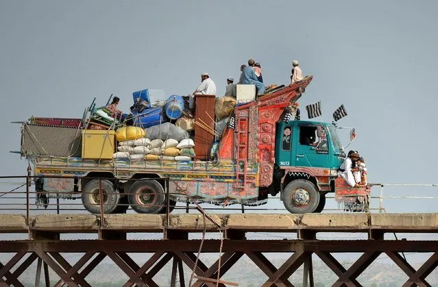 Pakistani civilians, fleeing from a military operation in North Waziristan tribal agency, cross a bridge on their arrival in Bannu district on June 20, 2014. Pakistani helicopter gunships pounded militant targets in the country's northwest June 20 killing up to 20 rebels, as the number of civilians fleeing an expected ground offensive passed 150,000. (Photo by A. Majeed/AFP Photo)