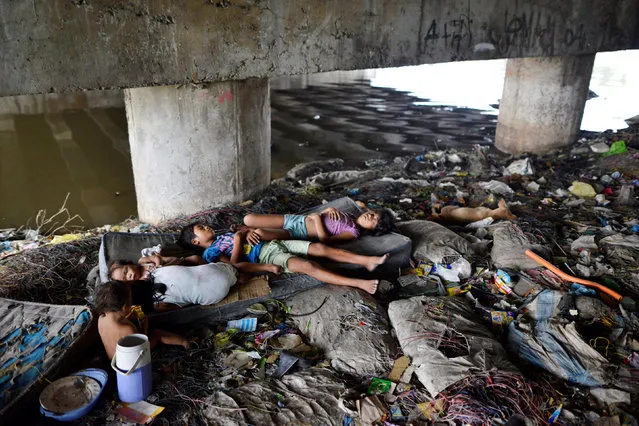 Children sleep amidst rubbish under a bridge in Paranaque city, Metro Manila, Philippines May 31, 2016. (Photo by Ezra Acayan/Reuters)