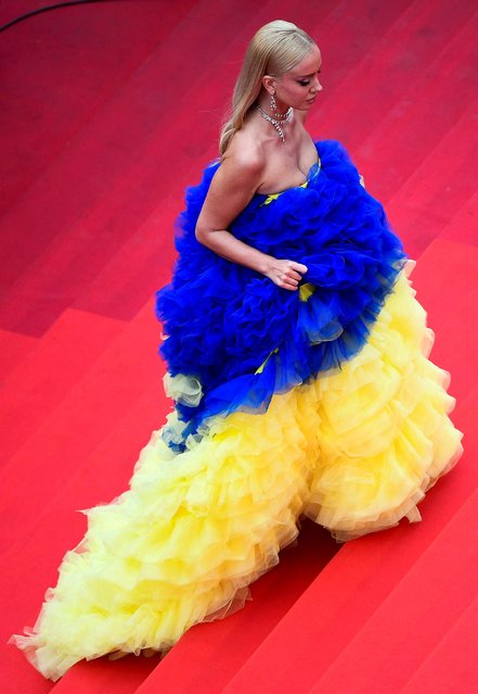 A guest wearing a dress in the colors of the Ukrainian flag walks the red carpet at the Screening of film “Les Amandiers” (Forever Young) during the 75th annual Cannes film festival at Palais des Festivals on May 22, 2022 in Cannes, France. (Photo by Piroschka Van De Wouw/Reuters)