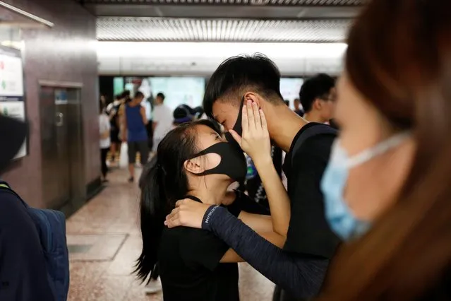 Protesters share a moment at Mei Foo underground MTR station, after protesters moved into the station following tear gas fired by riot police, in Hong Kong, China August 11, 2019. (Photo by James Pomfret/Reuters)