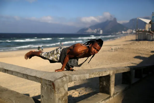 A youth practices parkour at the Ipanema beach in Rio de Janeiro, Brazil, June 18, 2016. (Photo by Pilar Olivares/Reuters)