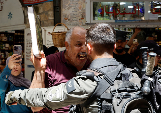 A man holds a copy of Koran as Israeli police blockade the entrance to Al-Aqsa compound also known to Jews as Temple Mount, following a visit to the site by Israel's hard-right National Security Minister Itamar Ben-Gvir, in Jerusalem's Old City on July 27, 2023. (Photo by Ammar Awad/Reuters)