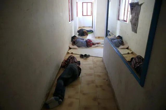 Migrants from Afghanistan sleep at a hallway of a deserted hotel on the Greek island of Kos, August 12, 2015. (Photo by Alkis Konstantinidis/Reuters)