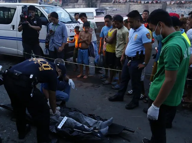 Members of the Philippine National Police (PNP) Scene of the Crime Operatives (SOCO) examine the scene of a crime where an alleged drug dealer was summarily executed in Manila, Philippines, 01 July 2016. Controversial politician Rodrigo Duterte, who was sworn in as the new president of the Philippines on 30 June, advised policemen to do their duty. He won voter confidence vowing to wipe out crime and drugs - two of the biggest issues in the country - but he has been harshly criticized by rights groups for advocating extrajudicial killings to bring down crime rates. The number of traffickers killed in the Philippines since Duterte won the elections has increased by 200 percent, according to police data. (Photo by Francis R. Malasig/EPA)