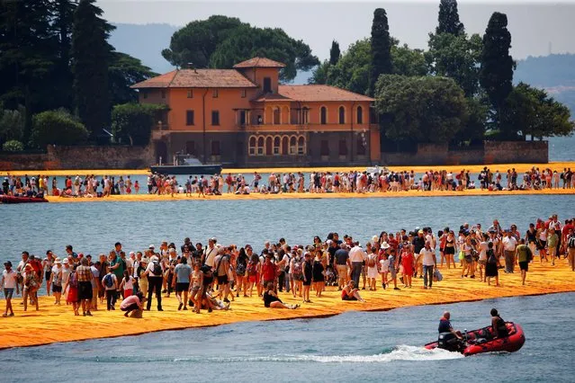 People walk on the installation “The Floating Piers” on Lake Iseo by Bulgarian-born artist Christo Vladimirov Yavachev, known as Christo, at the installation's last weekend near Sulzano, northern Italy, July 2, 2016. (Photo by Wolfgang Rattay/Reuters)