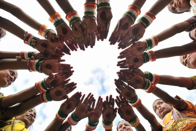 Indian girls wear tri colour bangles practice prior to take part during Independence Day celebrations in Secunderabad,the twin city of Hyderabad, on August 15, 2017.Indian Independence Day is celebrated annually on August 15, and this year marks 70 years since British India split into two nations – Hindu-majority India and Muslim-majority Pakistan – and millions were uprooted in one of the largest mass migrations in history. (Photo by Noah Seelam/AFP Photo)